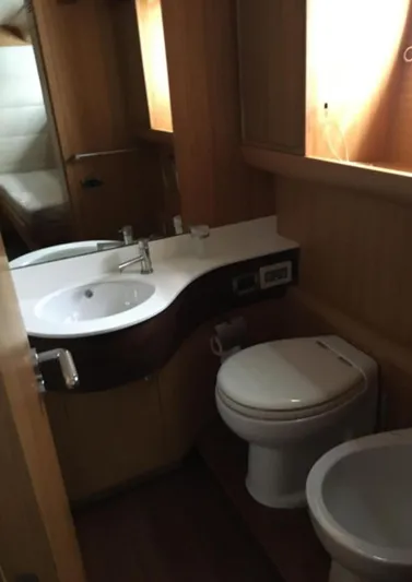  Yacht Photos Pics 2005 Canados 86 Fly yacht bathroom with modern fixtures and wooden cabinetry.