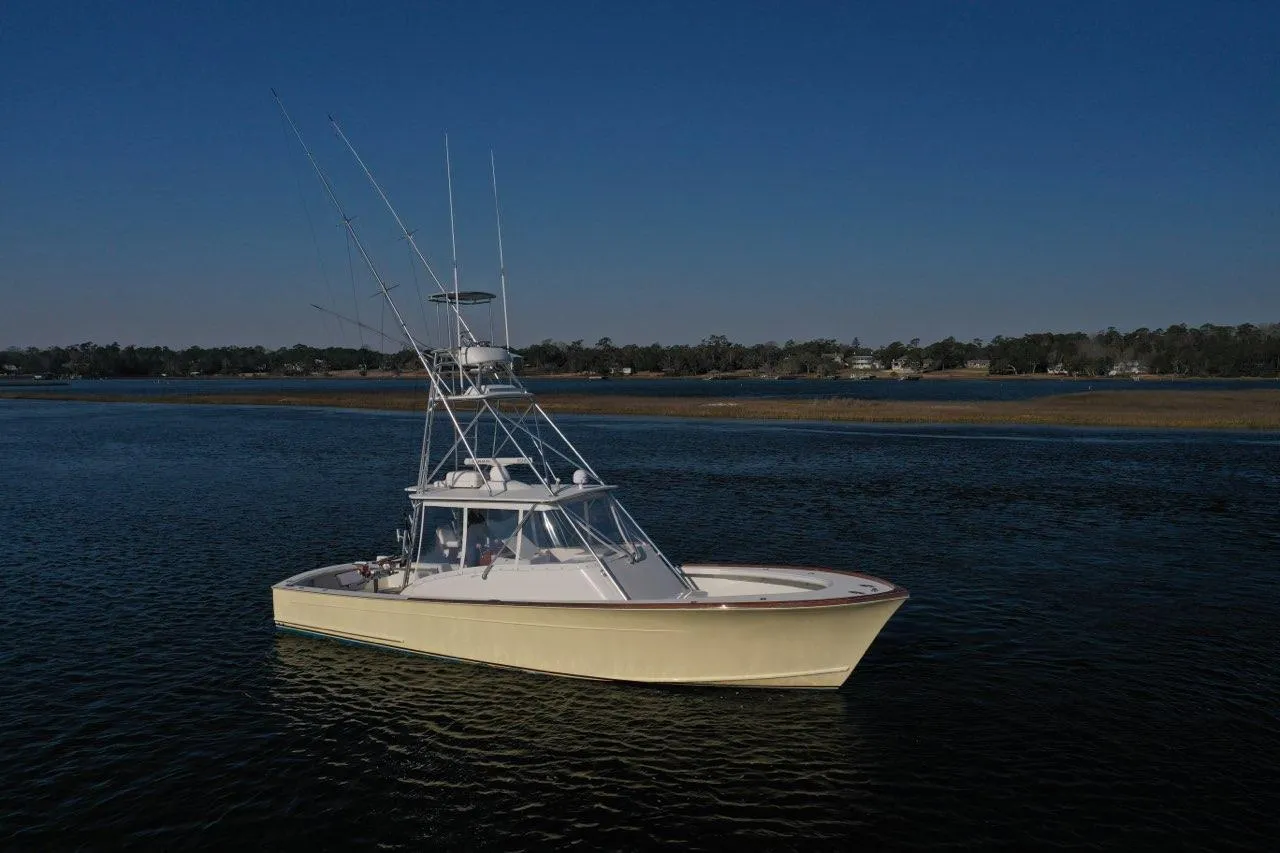 2007 Gamefisherman 42 Walkaround boat on calm water under clear blue sky.