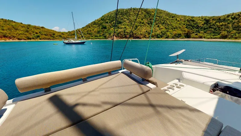 Aquatic Odyssey Yacht Photos Pics 2022 Bali CATSPACE catamaran in serene bay with lush green hills and clear blue water.