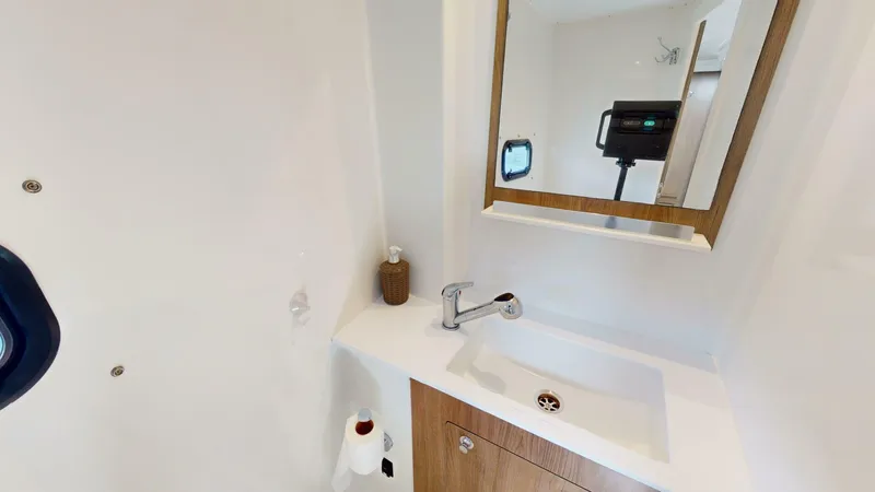 Aquatic Odyssey Yacht Photos Pics Modern bathroom in 2022 Bali CATSPACE yacht with sink, mirror, and porthole window.