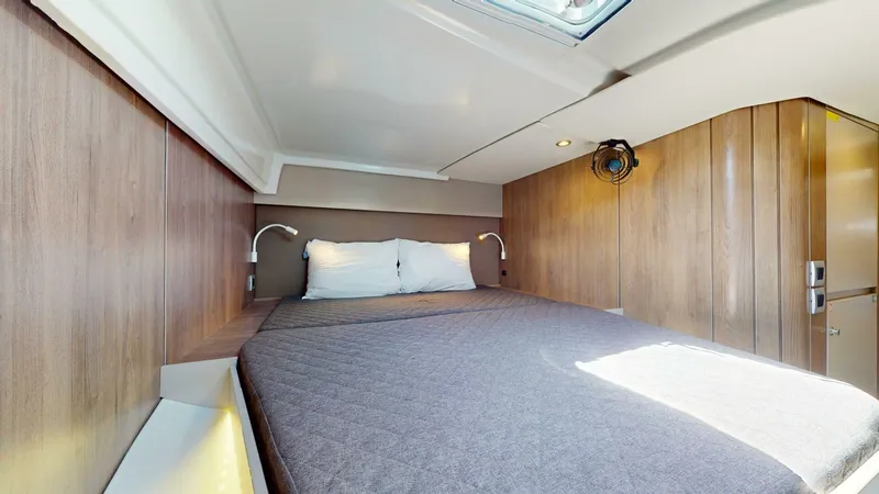 Aquatic Odyssey Yacht Photos Pics 2022 Bali CATSPACE yacht cabin with cozy bed, wooden walls, and modern lighting.