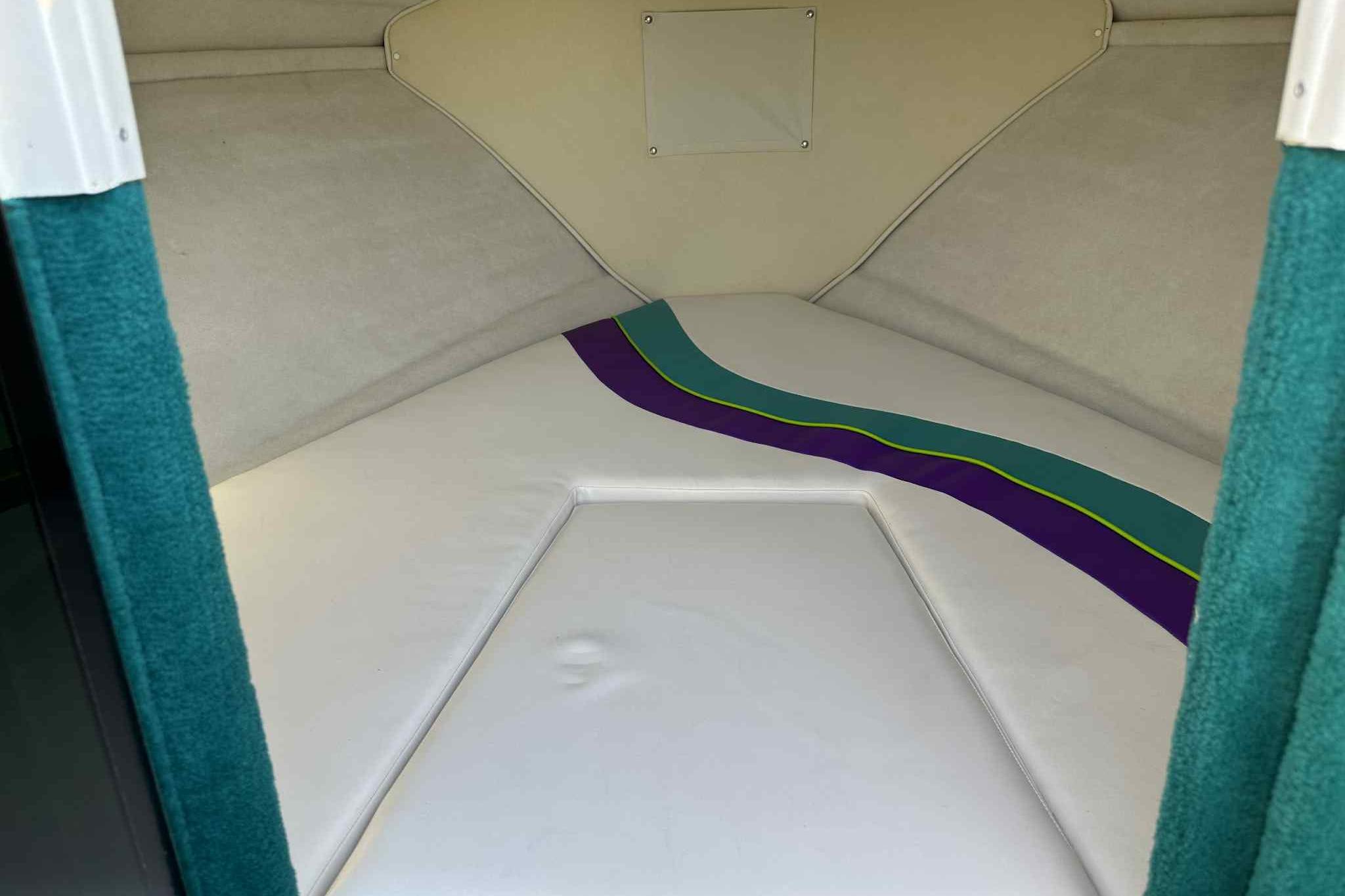 1993 Nova Spyder boat interior with colorful striped upholstery.