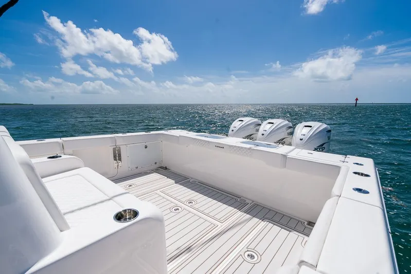 Caymas Yacht Photos Pics 2023 Caymas 401CC boat deck with triple outboard motors on open sea.