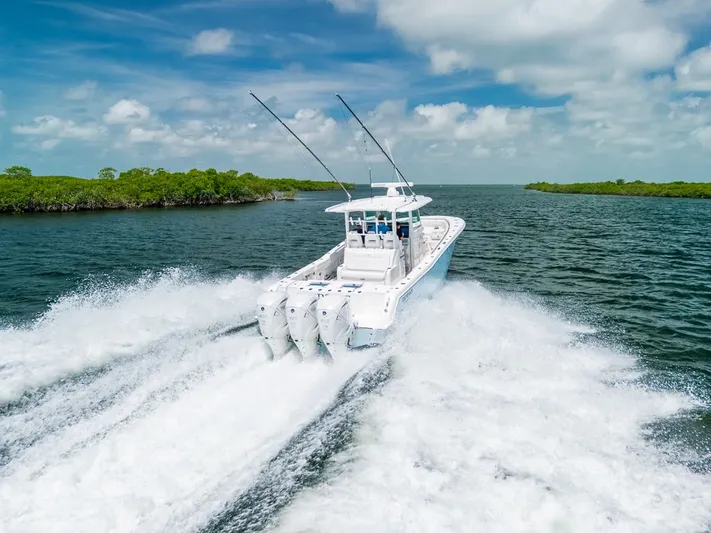 Caymas Yacht Photos Pics 2023 Caymas 401CC boat cruising on open water, leaving a wake behind.