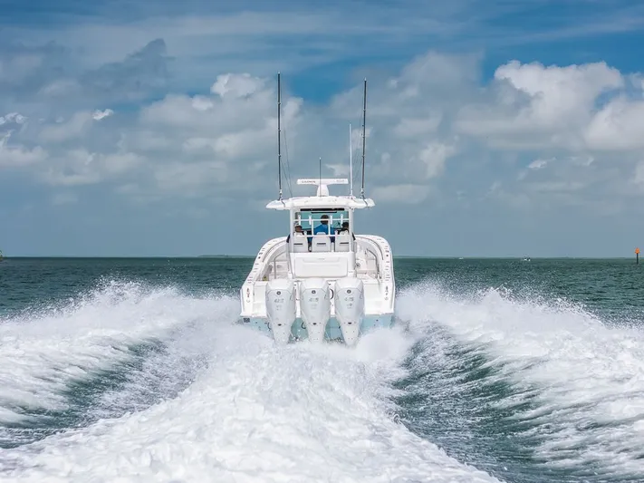 Caymas Yacht Photos Pics 2023 Caymas 401CC boat cruising on open water, leaving a wake behind.