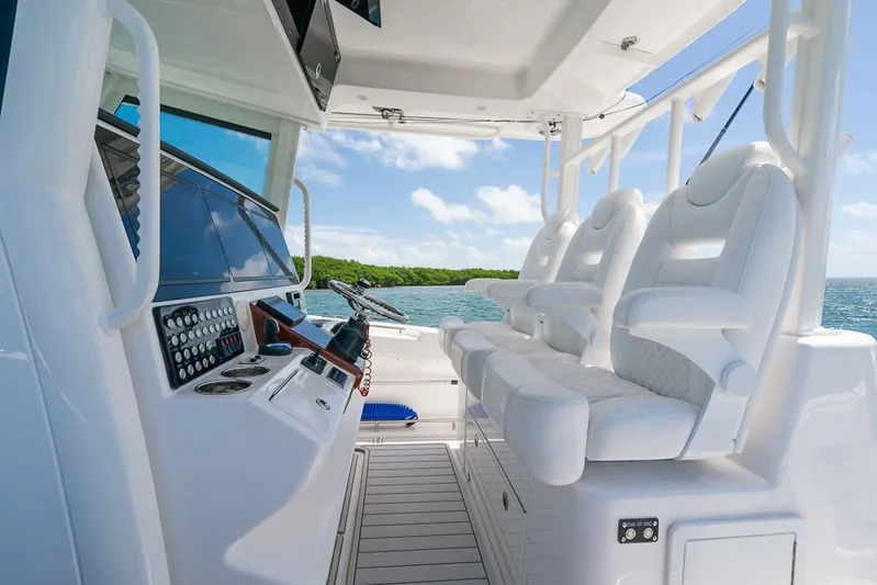 Caymas Yacht Photos Pics 2023 Caymas 401CC boat interior with white seating and control panel, ocean view.