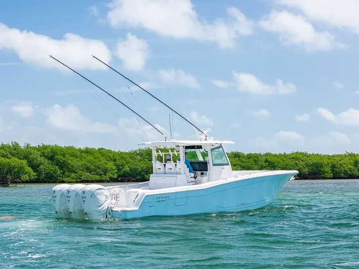 Caymas Yacht Photos Pics 2023 Caymas 401CC boat cruising on clear blue water with lush green mangroves.