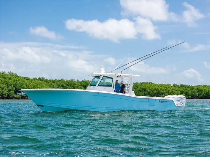 Caymas Yacht Photos Pics 2023 Caymas 401CC boat cruising on blue water under a clear sky.