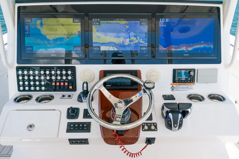 Caymas Yacht Photos Pics Control panel of 2023 Caymas 401CC boat with navigation screens and steering wheel.