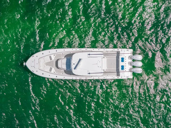 Caymas Yacht Photos Pics Aerial view of 2023 Caymas 401CC boat on vibrant green water.