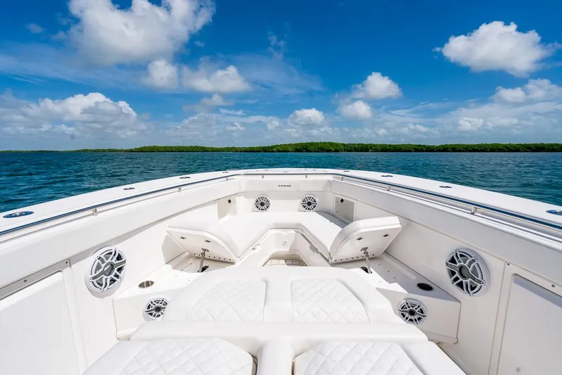 Caymas Yacht Photos Pics 2023 Caymas 401CC boat interior with white seating, ocean view, and blue sky.