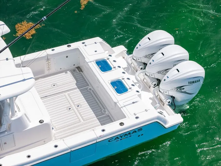Caymas Yacht Photos Pics 2023 Caymas 401CC boat with triple Yamaha outboard engines on green water.