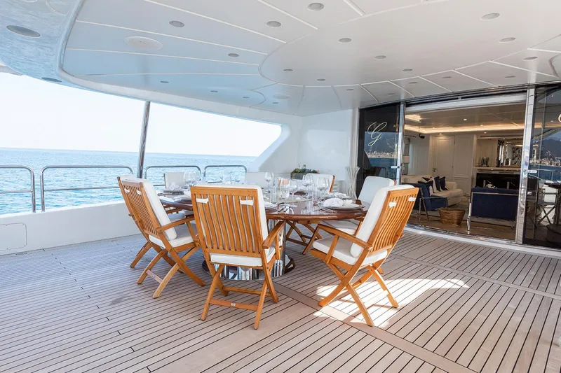 Georgia I Yacht Photos Pics Luxury dining area on 2009 Benetti Classic 120 yacht, featuring elegant wooden furniture.