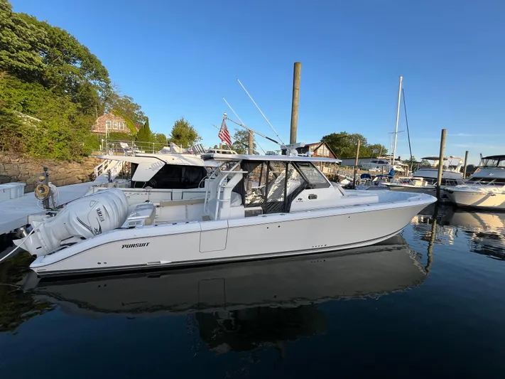  Yacht Photos Pics 2019 Pursuit S 408 Sport boat docked in a marina, reflecting on calm water.