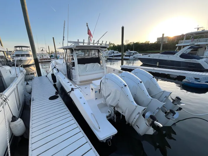  Yacht Photos Pics 2019 Pursuit S 408 Sport boat docked at marina with triple outboard engines.
