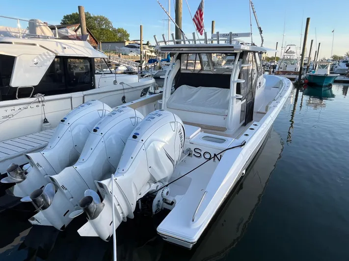  Yacht Photos Pics 2019 Pursuit S 408 Sport boat docked with triple outboard engines.