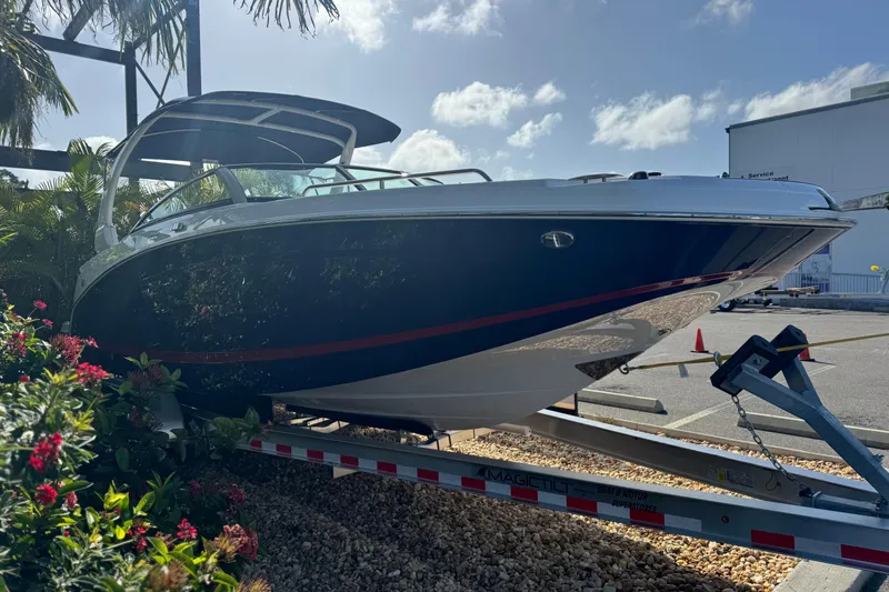  Yacht Photos Pics 2026 Four Winns HD8 OB boat on trailer, surrounded by tropical plants.