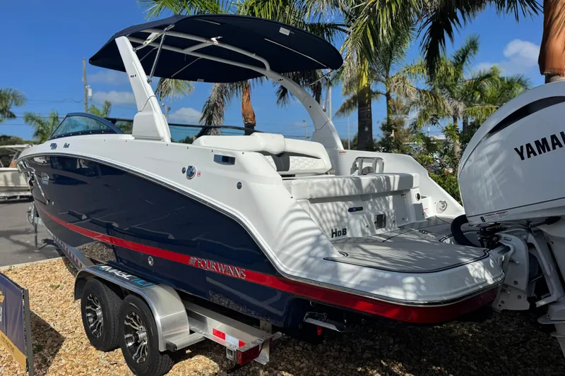  Yacht Photos Pics 2026 Four Winns HD8 OB boat with Yamaha engine, parked on a trailer, surrounded by palm trees.