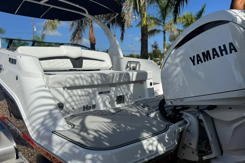  Yacht Photos Pics 2026 Four Winns HD8 OB boat with Yamaha outboard motor, parked under palm trees.