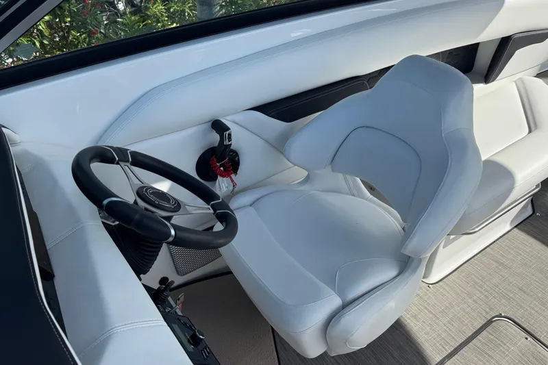  Yacht Photos Pics 2026 Four Winns HD8 OB boat cockpit with white captain's chair and steering wheel.