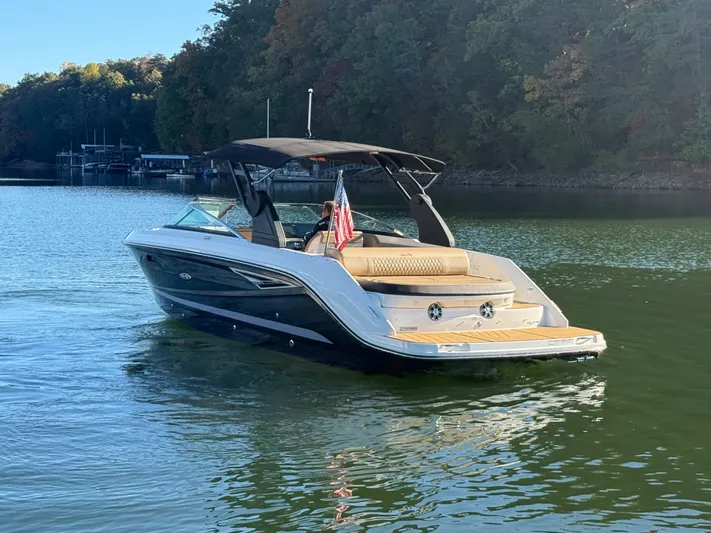  Yacht Photos Pics 2023 Sea Ray 280 SLX boat cruising on a serene lake with lush forest backdrop.