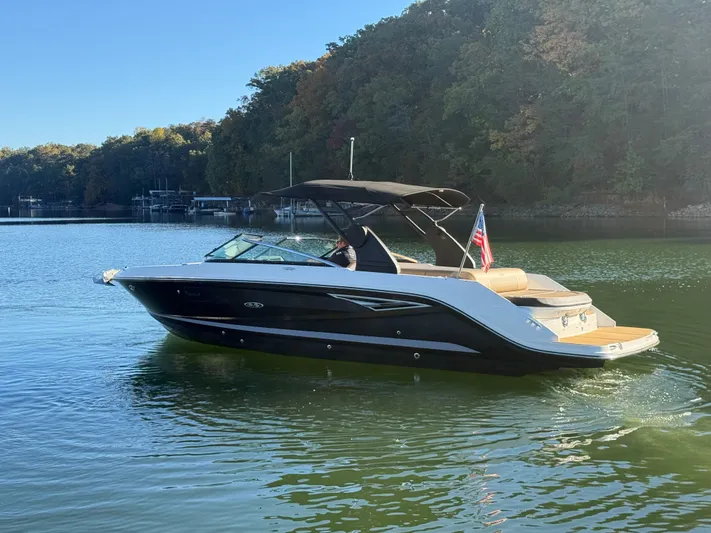  Yacht Photos Pics 2023 Sea Ray 280 SLX boat cruising on a serene lake with forested shoreline.