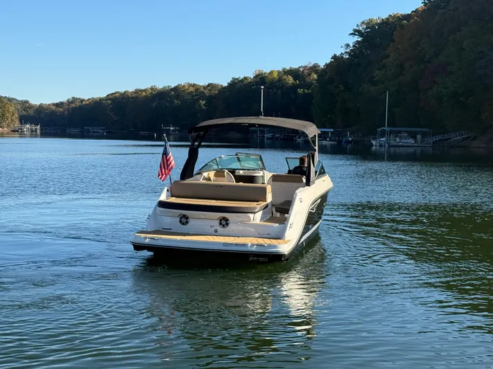  Yacht Photos Pics 2023 Sea Ray 280 SLX boat cruising on a serene lake with lush forest backdrop.