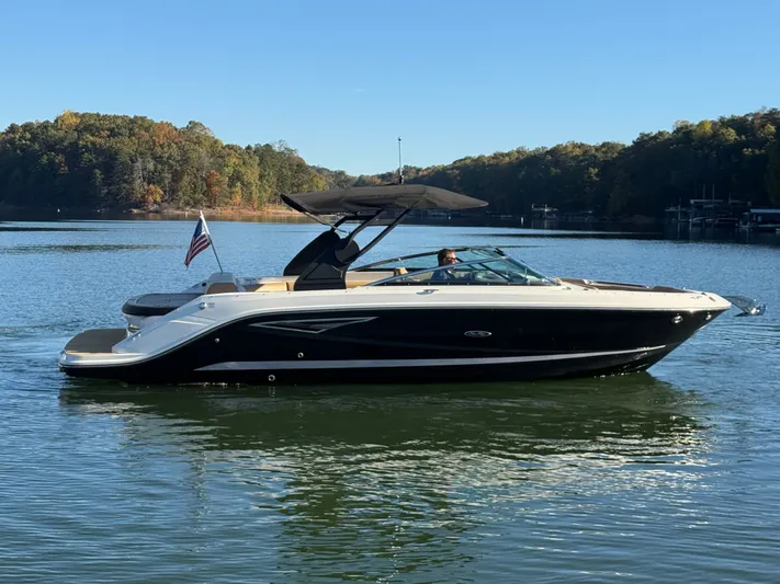  Yacht Photos Pics 2023 Sea Ray 280 SLX boat cruising on a serene lake with forested shoreline.