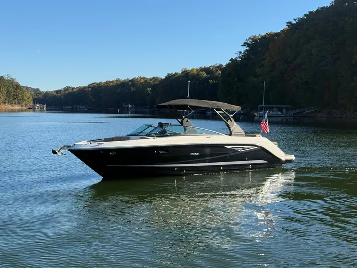  Yacht Photos Pics 2023 Sea Ray 280 SLX boat on a serene lake with forested shoreline.