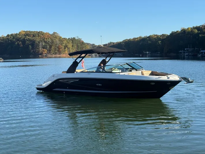  Yacht Photos Pics 2023 Sea Ray 280 SLX boat cruising on a serene lake with forested shoreline.