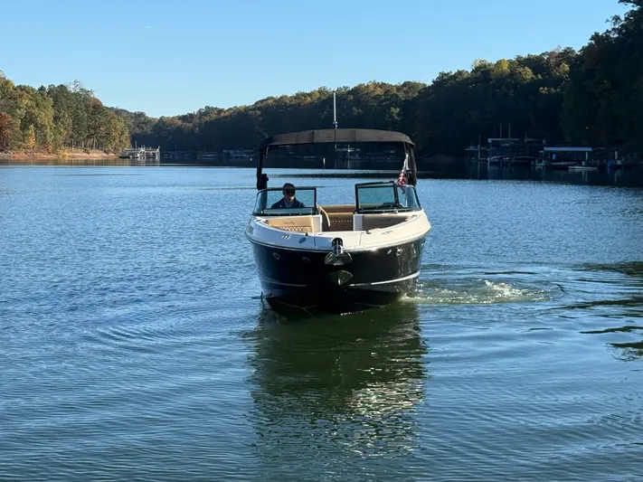  Yacht Photos Pics 2023 Sea Ray 280 SLX boat cruising on a serene lake with forested shoreline.