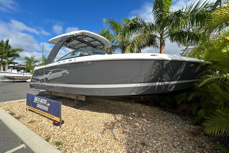  Yacht Photos Pics 2026 Four Winns H9 OB boat displayed outdoors with palm trees and blue sky.