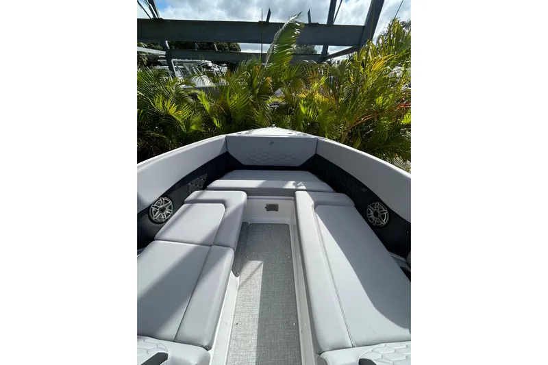  Yacht Photos Pics 2026 Four Winns H9 OB boat interior with gray seating and lush greenery background.