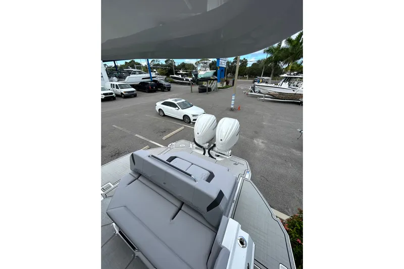  Yacht Photos Pics 2026 Four Winns H9 OB boat with dual outboard motors in a parking lot.