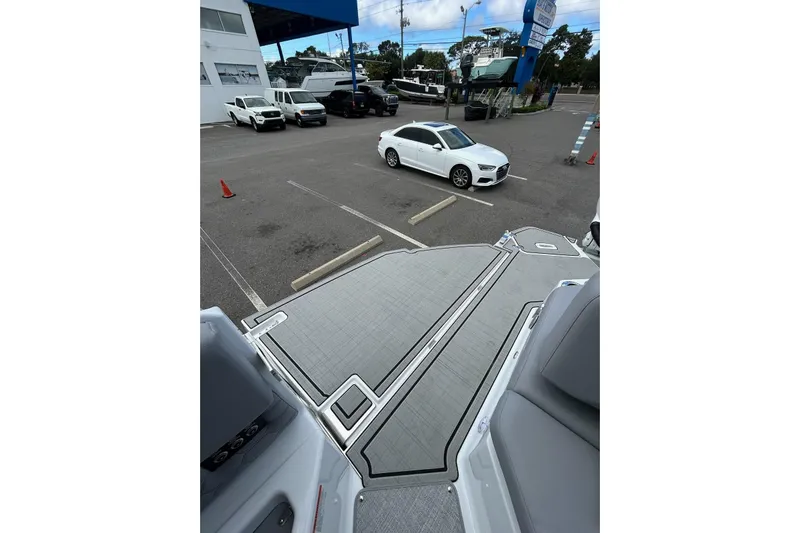  Yacht Photos Pics 2026 Four Winns H9 OB boat deck in a parking lot with cars.