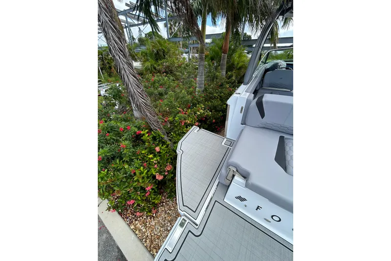  Yacht Photos Pics 2026 Four Winns H9 OB boat deck near tropical plants and palm trees.