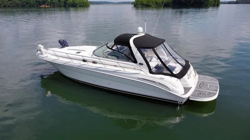  Yacht Photos Pics 2000 Sea Ray 410 Sundancer yacht on calm water, featuring sleek design and black canopy.