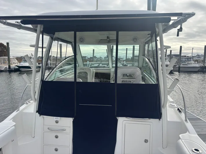  Yacht Photos Pics 2014 Boston Whaler 285 Conquest boat docked, featuring a covered cockpit and sleek design.