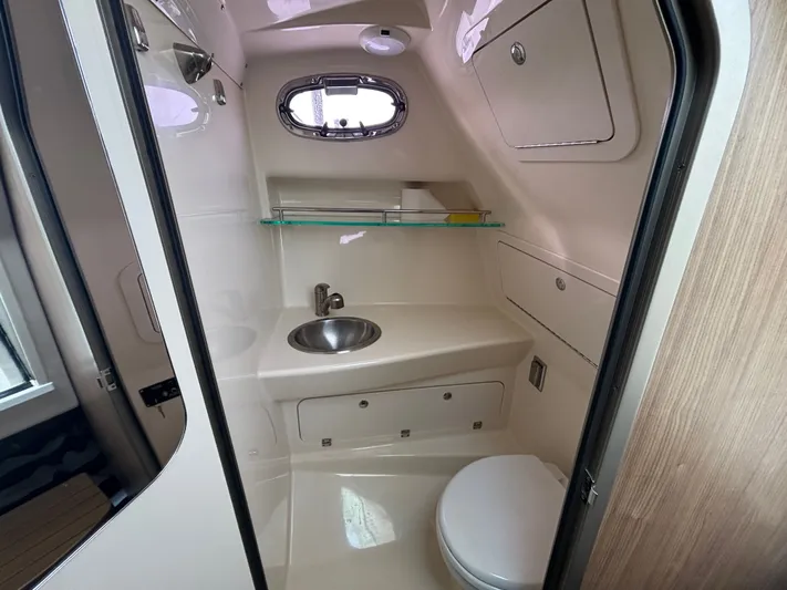  Yacht Photos Pics 2014 Boston Whaler 285 Conquest boat bathroom with sink, toilet, and storage cabinets.