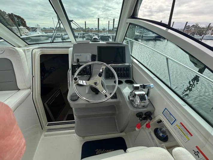  Yacht Photos Pics 2014 Boston Whaler 285 Conquest helm with steering wheel and navigation equipment.