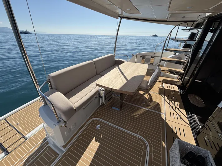 Barcajack Yacht Photos Pics 2022 Fountaine Pajot MY6 yacht deck with seating and table, overlooking calm sea.