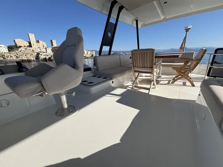 Barcajack Yacht Photos Pics Luxurious 2022 Fountaine Pajot MY6 yacht deck with seating and scenic coastal view.