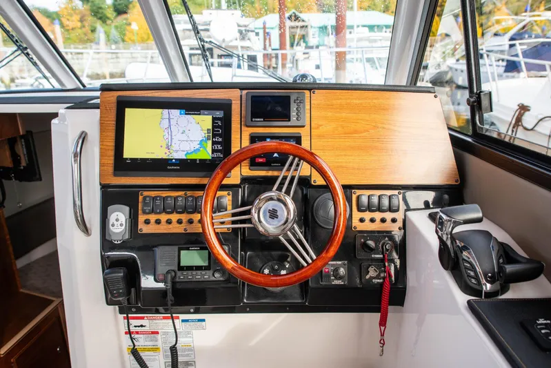  Yacht Photos Pics Helm of 2025 Cutwater C-288 Coupe with navigation display and wooden steering wheel.
