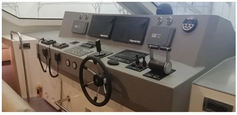  Yacht Photos Pics Control panel of 2025 Mazarin Catamaran HSF-58 with steering wheel and navigation equipment.