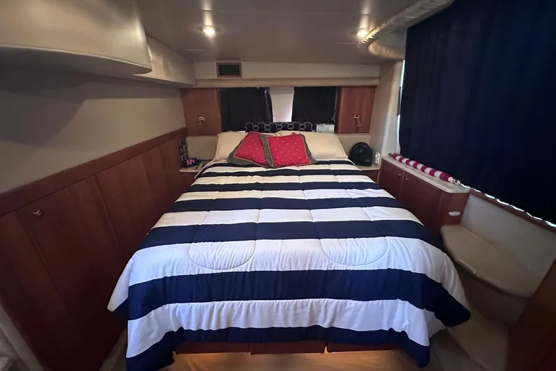 Blue Yonder Yacht Photos Pics Luxurious bedroom in 2004 Meridian 459 Motoryacht with striped bedding and wooden cabinetry.