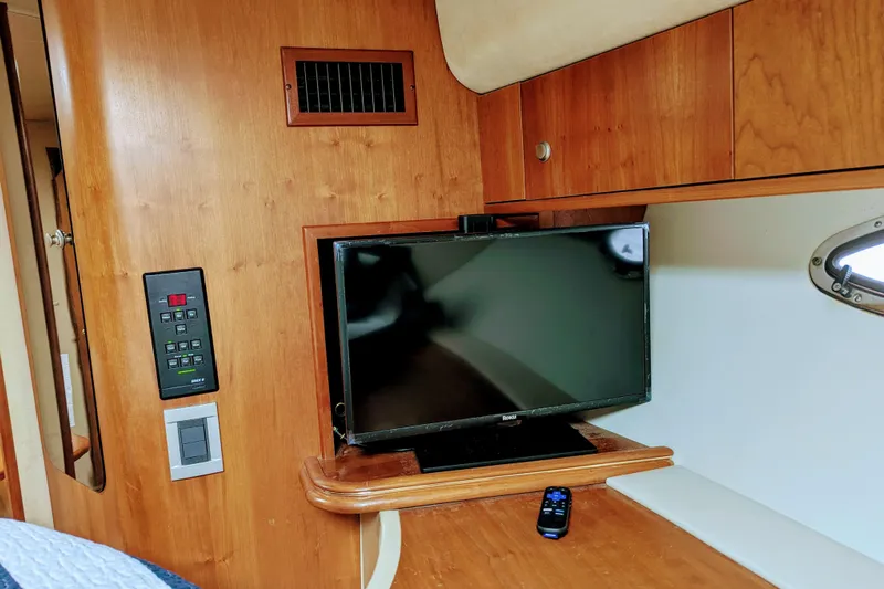  Yacht Photos Pics Interior of 2000 Cruisers Yachts 3870 Express with TV and remote on wooden surface.