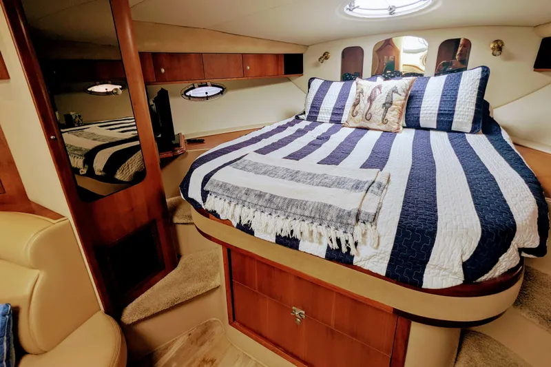  Yacht Photos Pics Luxurious cabin interior of 2000 Cruisers Yachts 3870 Express with striped bedding.
