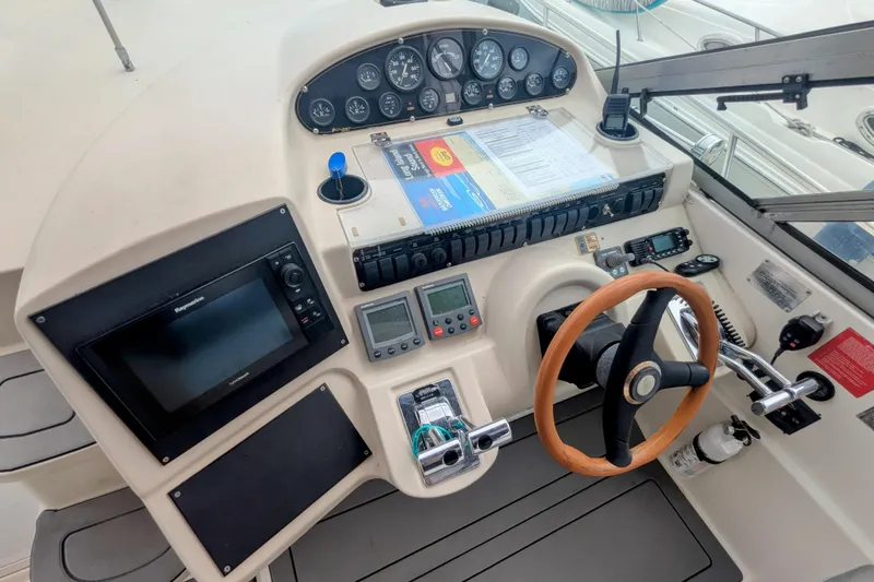  Yacht Photos Pics 2000 Cruisers Yachts 3870 Express helm with navigation equipment and wooden steering wheel.