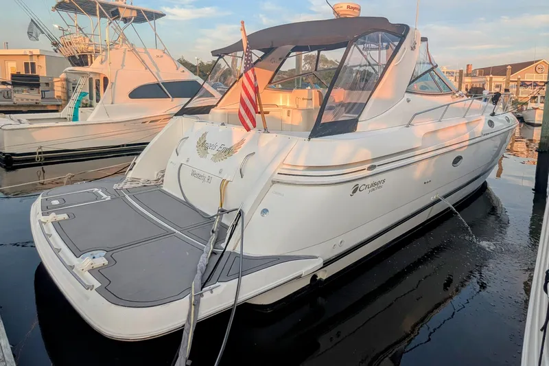  Yacht Photos Pics 2000 Cruisers Yachts 3870 Express docked at marina, rear view with American flag.