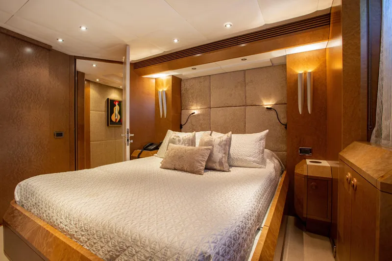 Benita Blue Yacht Photos Pics Luxurious bedroom interior on 2005 Evolution Yachts Custom model, featuring elegant wood finishes and soft lighting.